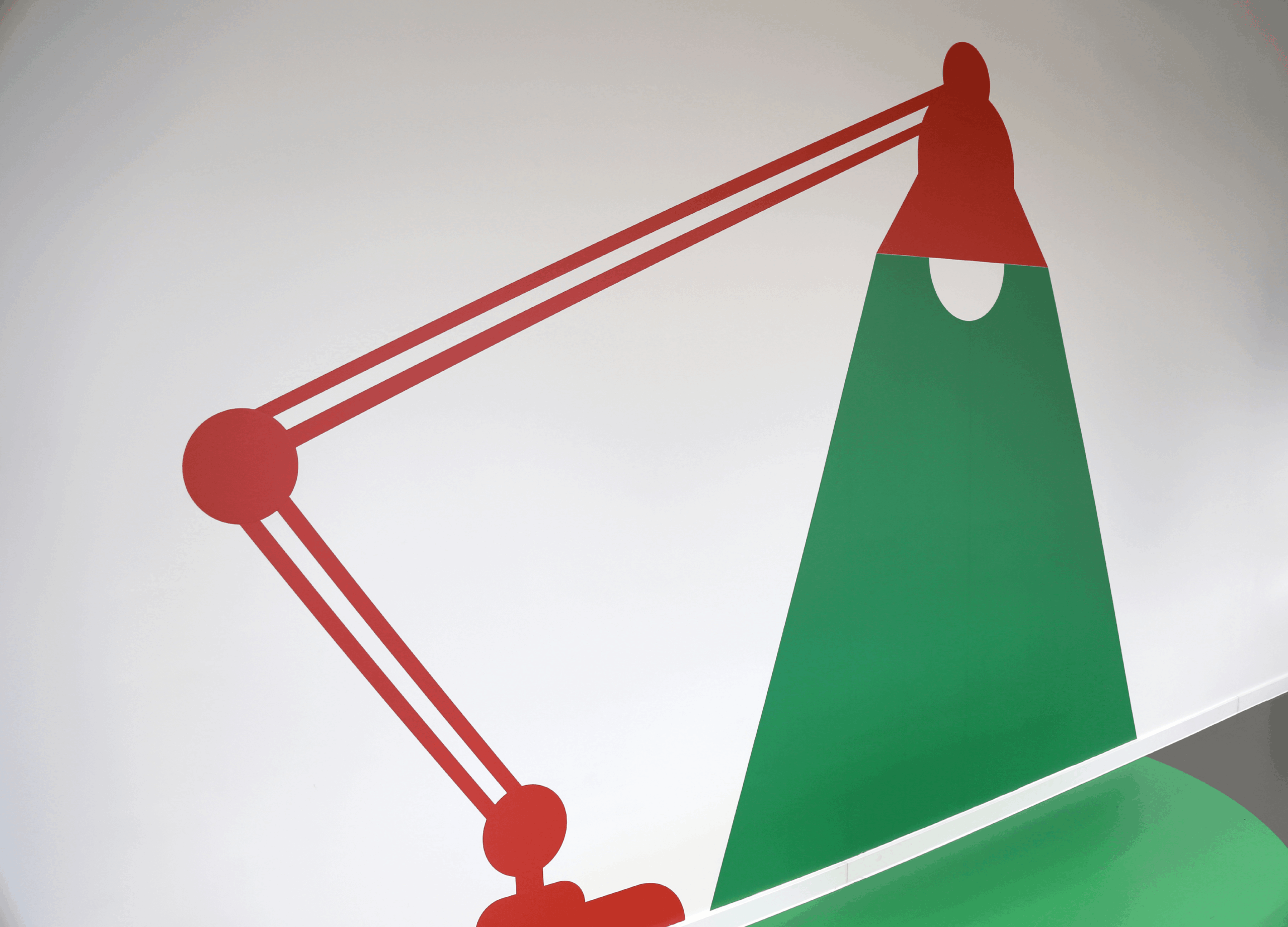 Illustration murale minimaliste en deux dimensions représentant une lampe d'architecte articulée rouge. Le faisceau lumineux projeté par la lampe est représenté par une large forme géométrique verte pleine sur un mur blanc.