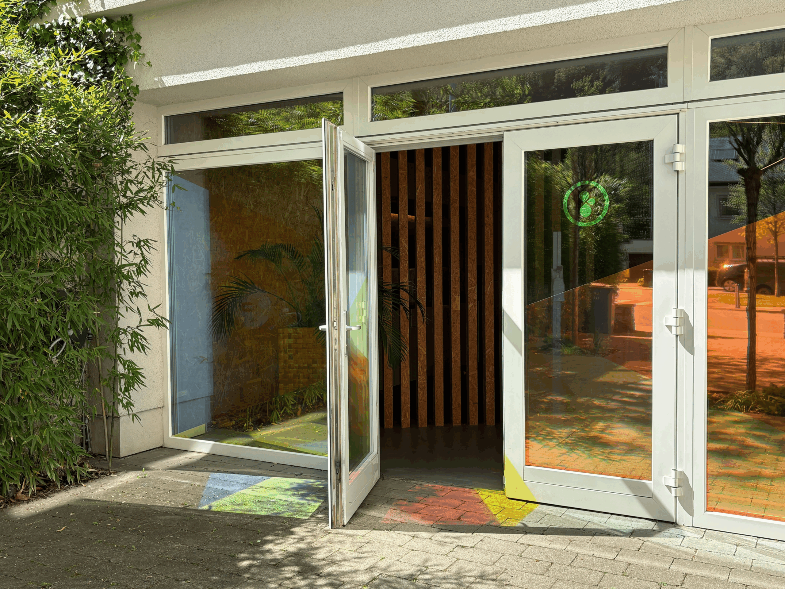 Entrée vitrée de h2a avec porte ouverte, signalétique multicolore, holographique et lumière naturelle