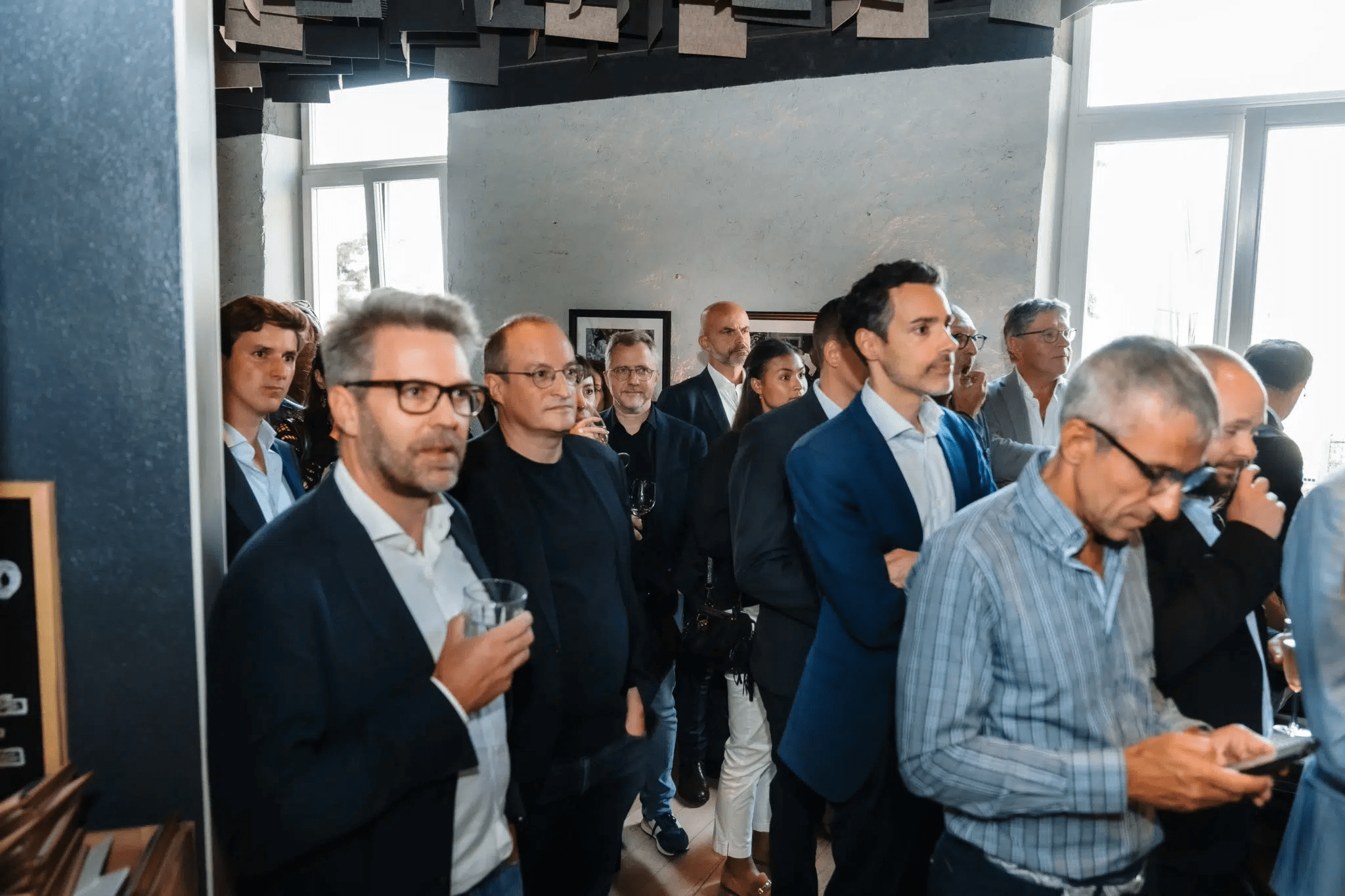 Foule d'hommes debout assistants à la présentation du magazine.