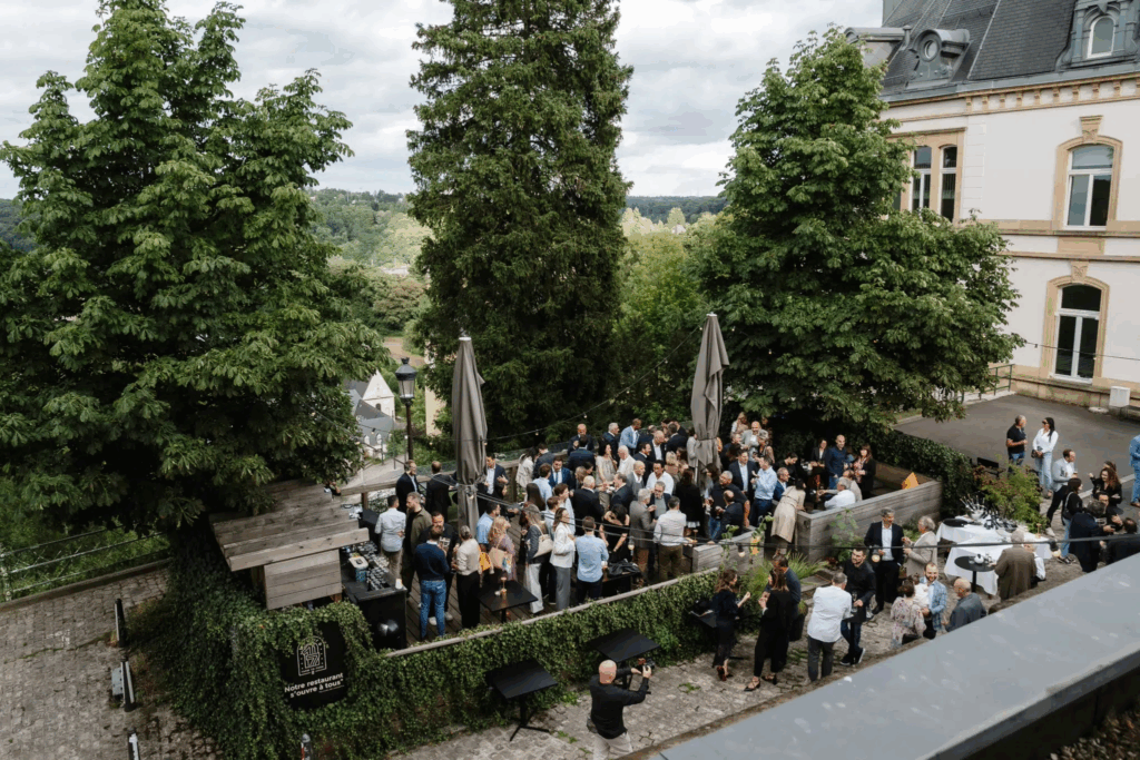 Photo prise de haut, où l'on voit la foule des invités à la soirée de lancement en extérieur qui échangent.
