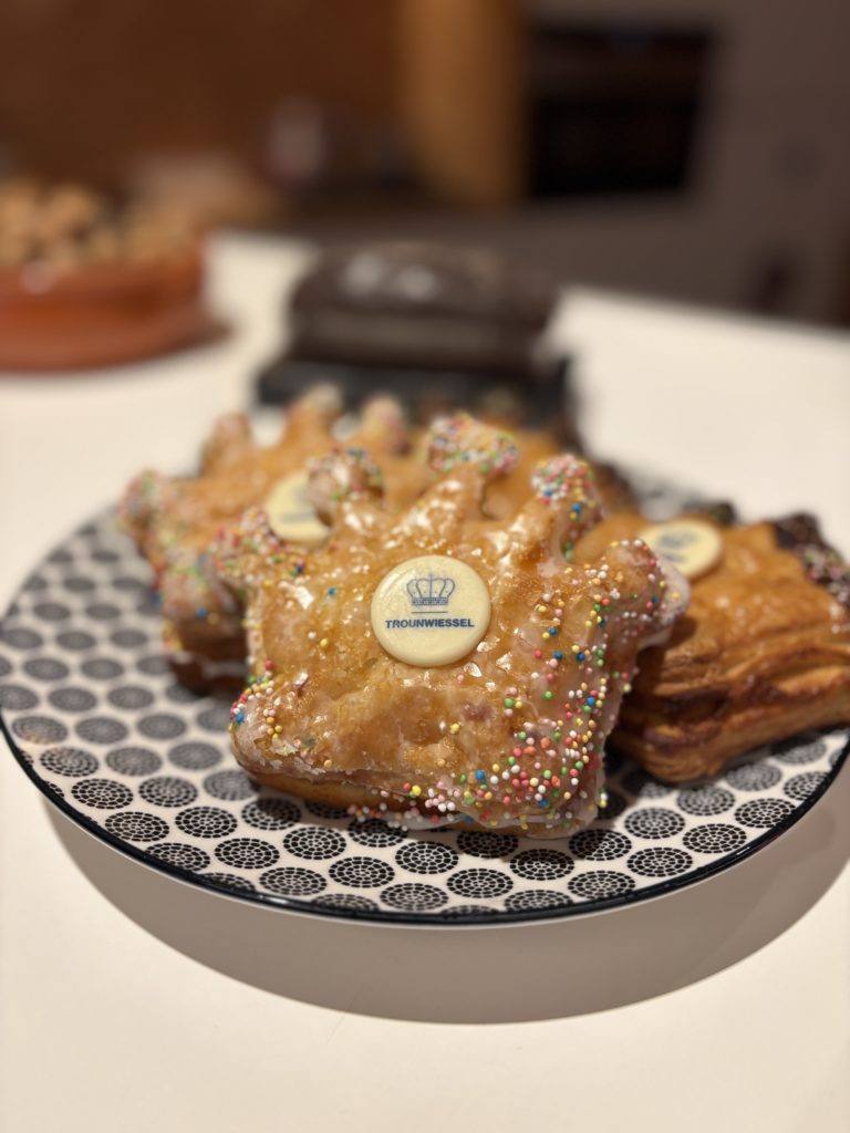 Pâtisseries en forme de couronne glacées et multicolores, pastille « TROUNWIESSEL » sur assiette