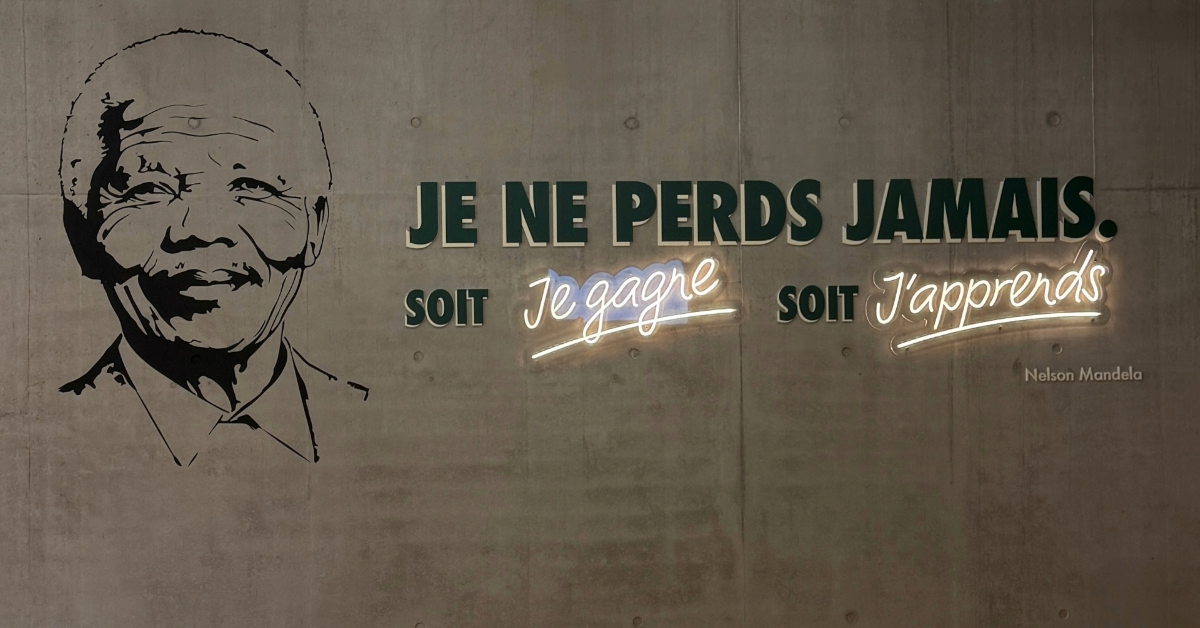 Portrait stylisé d’un homme et citation murale : « JE NE PERDS JAMAIS. Soit je gagne, soit j’apprends.