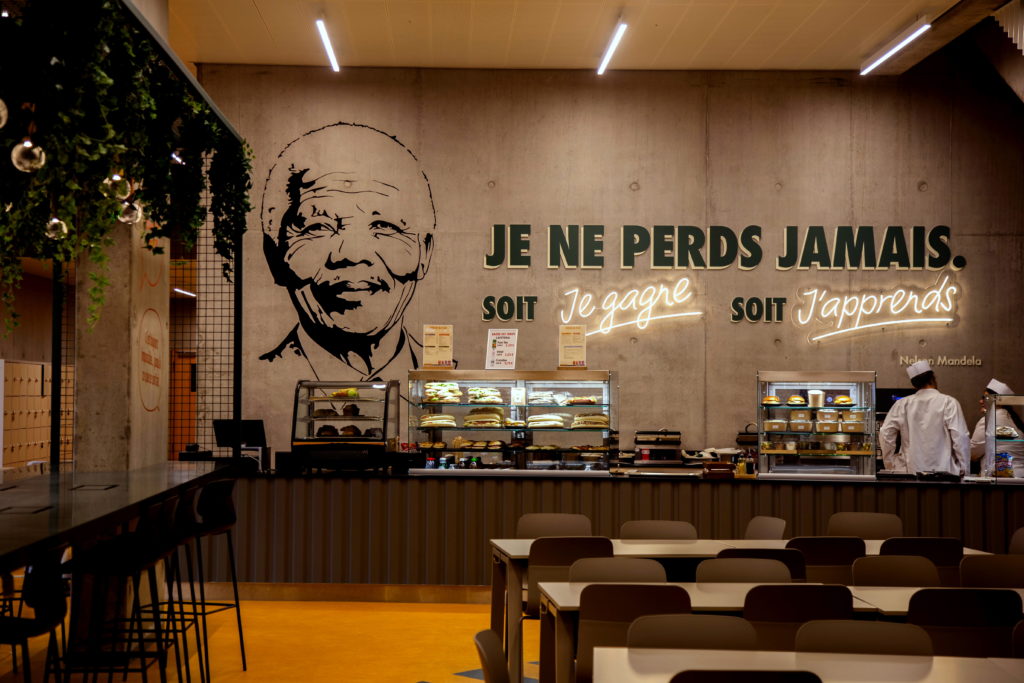 Portrait de Nelson Mandela en noir sur un mur gris, avec la phrase : "Je ne perds jamais. Soit je gagne, soit j'apprends."