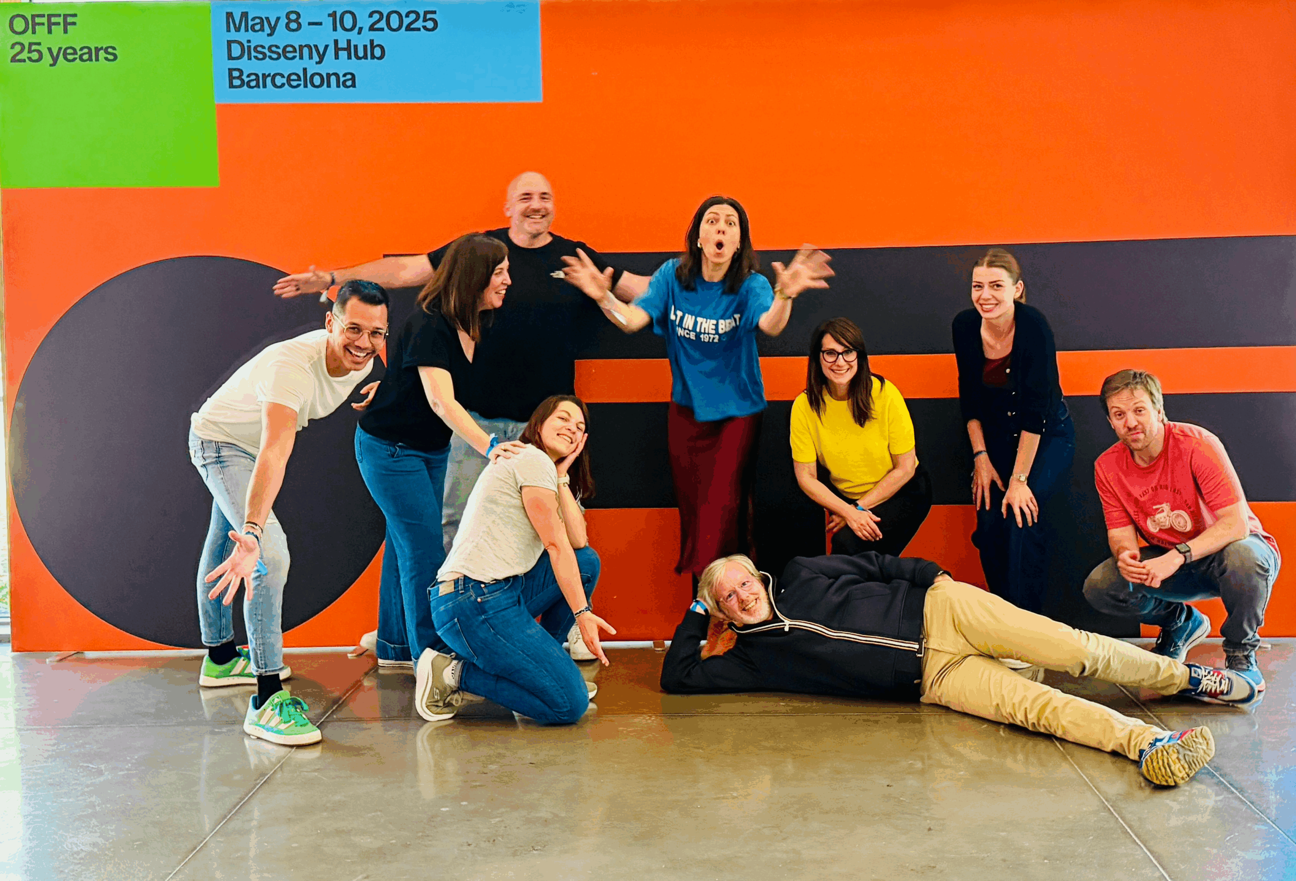 groupe de 8 personnes devant une affiche 