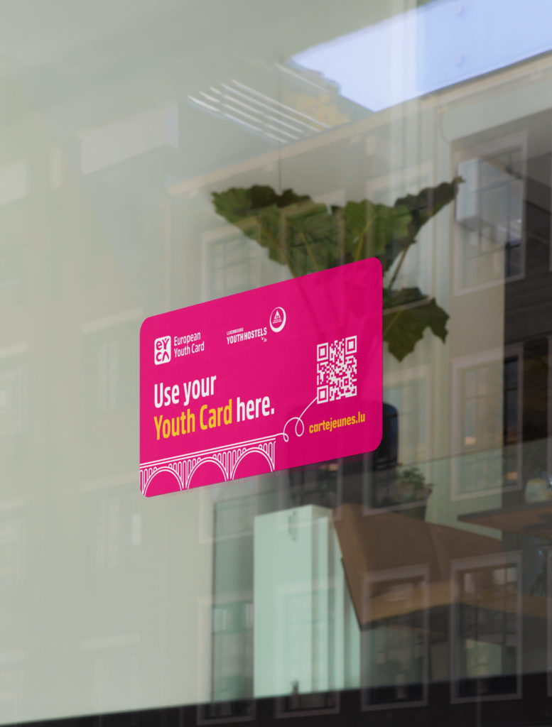 Autocollant partenaire European Youth Card apposé sur une vitrine pour signaler l'acceptation de la carte et les réductions disponibles.