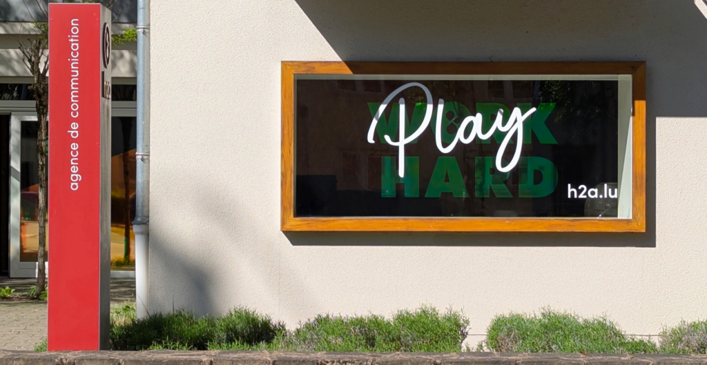 devanture agence de communication h2a au Luxembourg, avec slogan "Work Hard Play Hard"