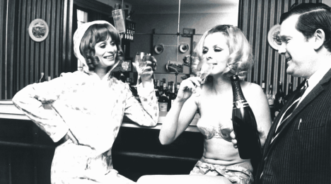 deux femmes et un homme boivent du champagne à un bar