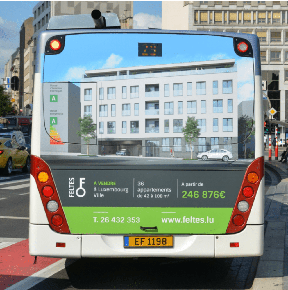 Communication d'un projet immobilier mise en avant par une publicité immobilière sur l’arrière d’un bus en circulation