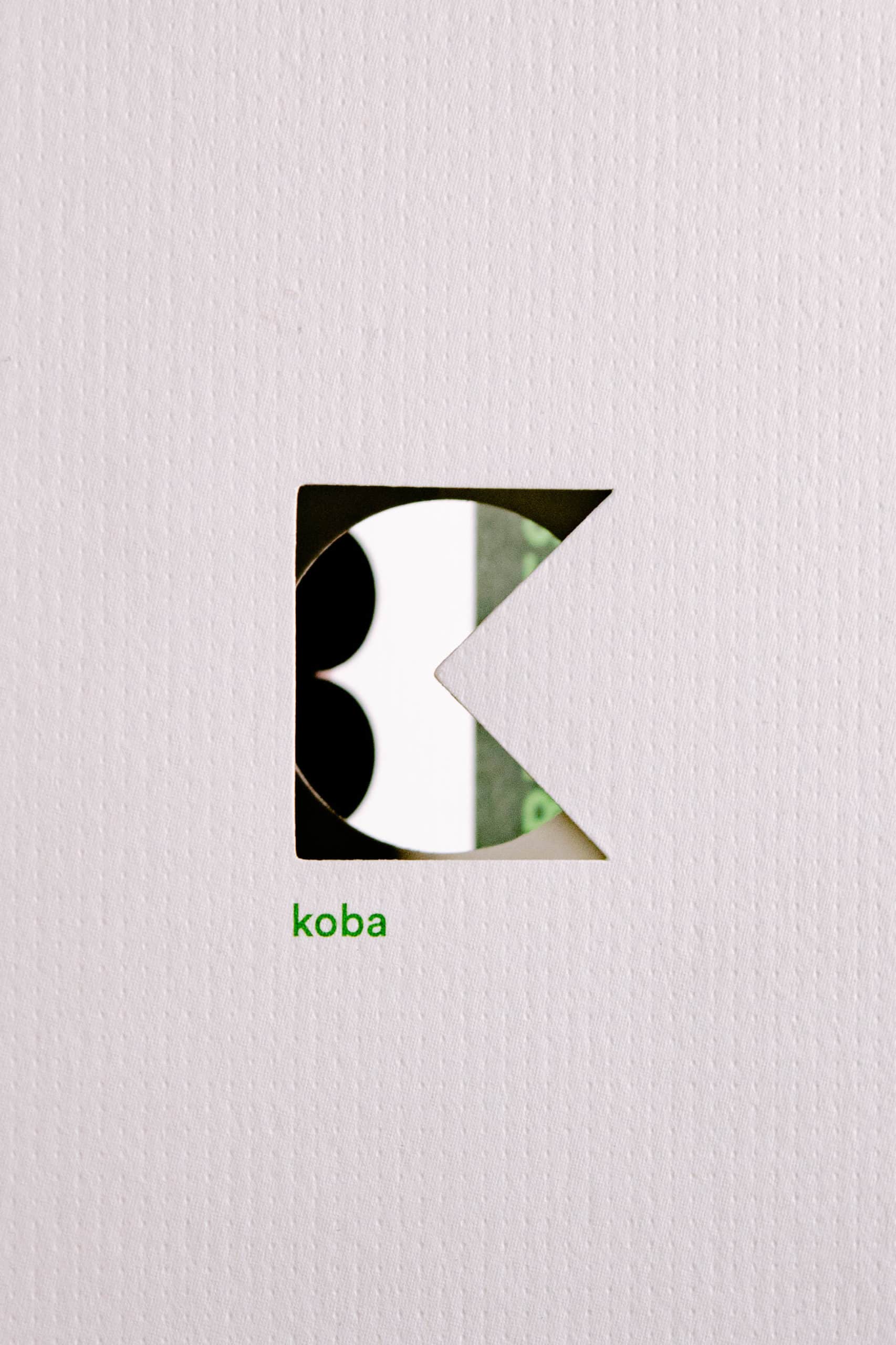 Carte pliée avec logo Koba découpé au laser, sur fond blanc