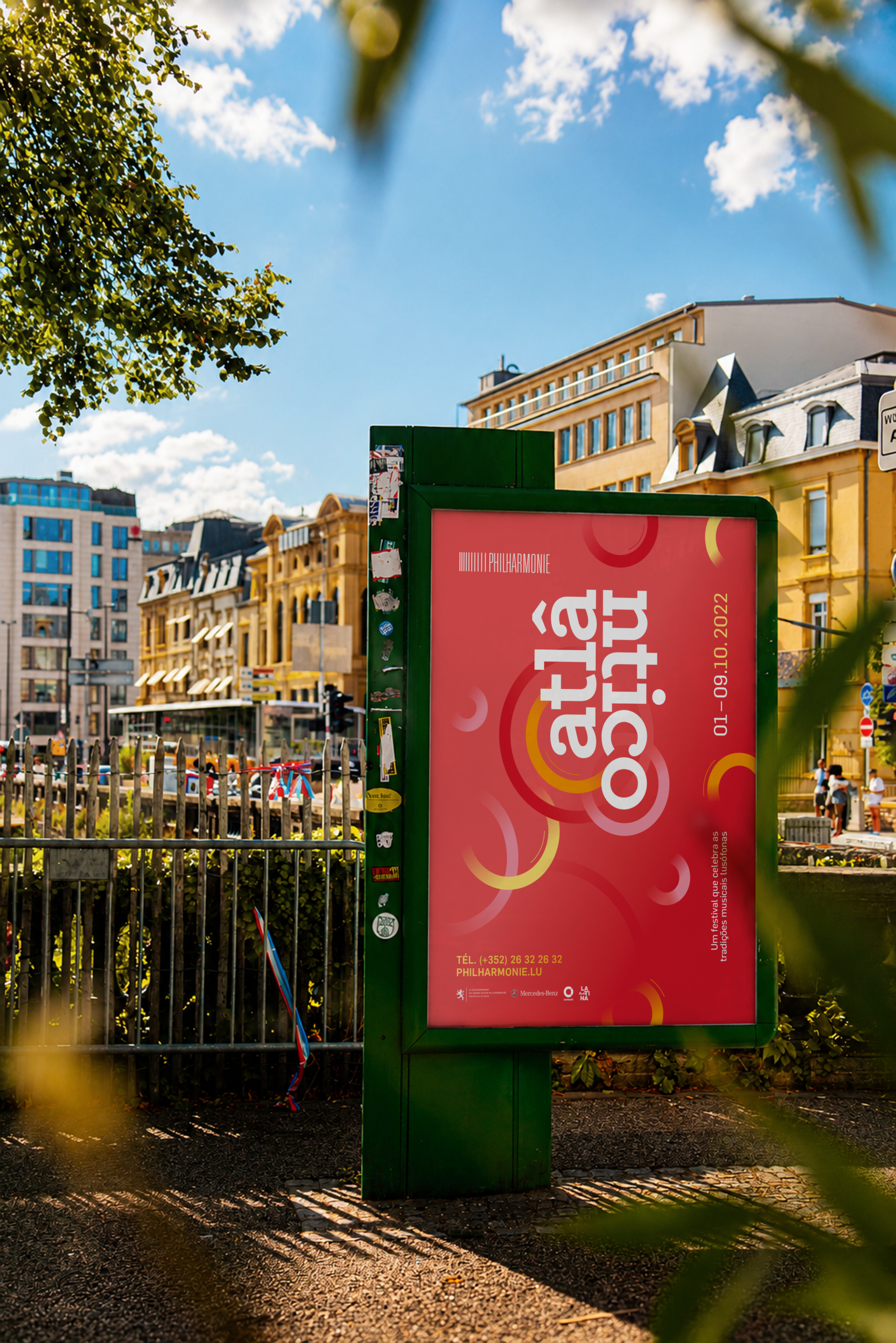 Affiche publicitaire rouge du festival musical Atlântico intégrée sur un mobilier urbain en ville.