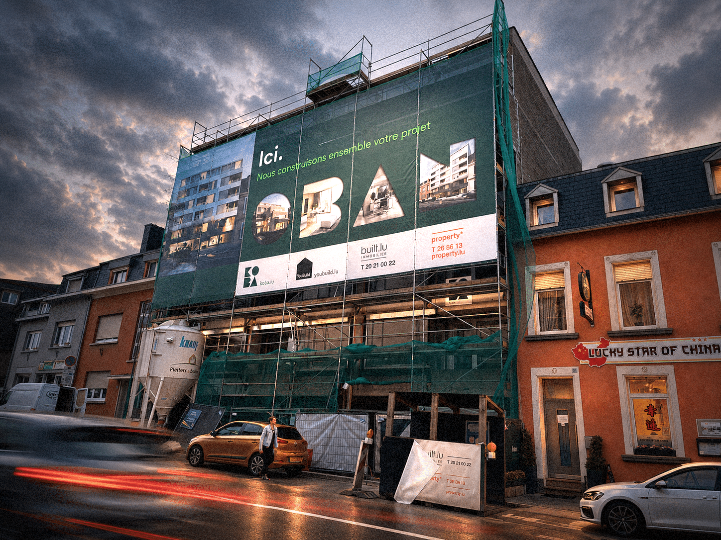 Bâche de chantier Koba affichée sur un immeuble en construction, en centre-ville