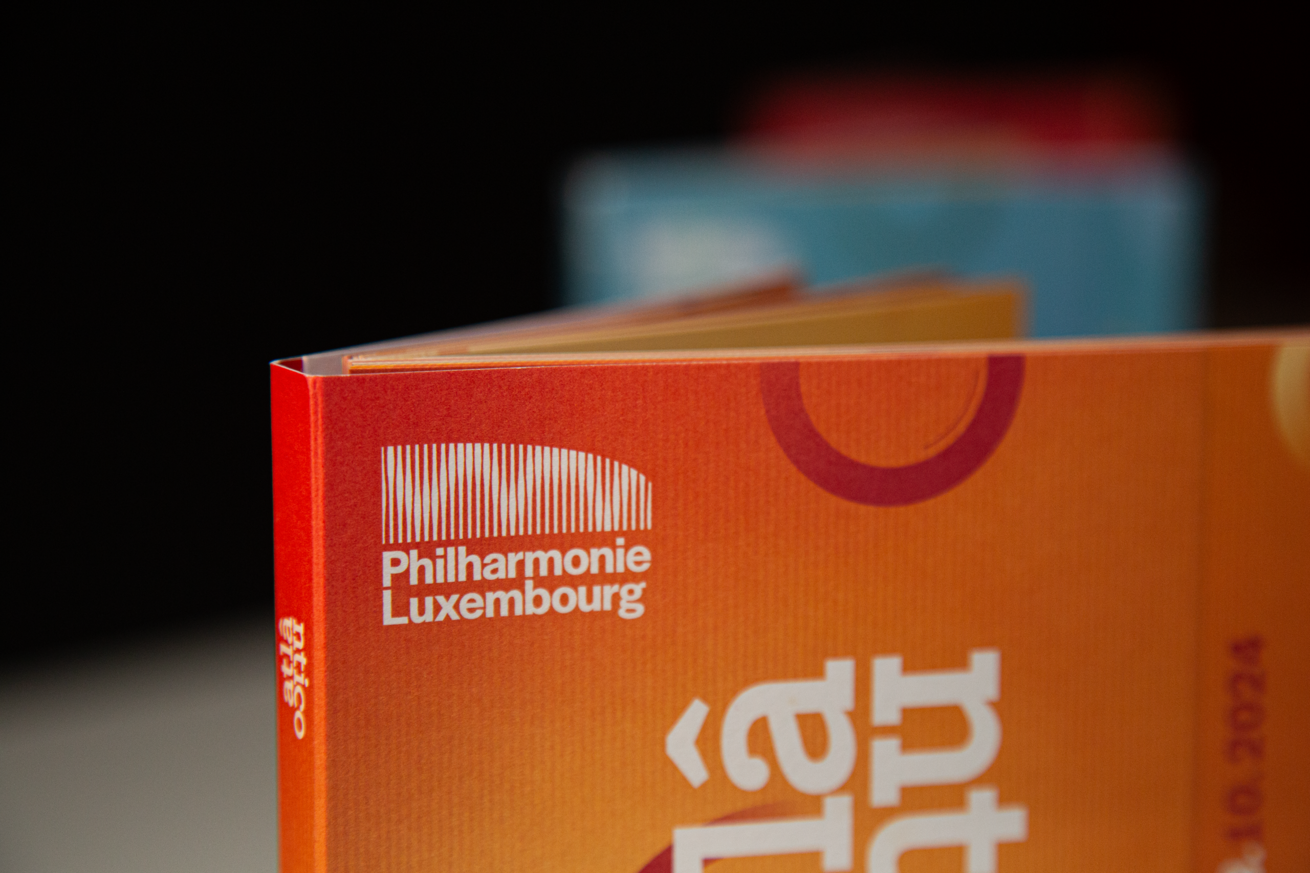 Détail de la couverture orange de la brochure du festival Atlântico de la Philharmonie Luxembourg.