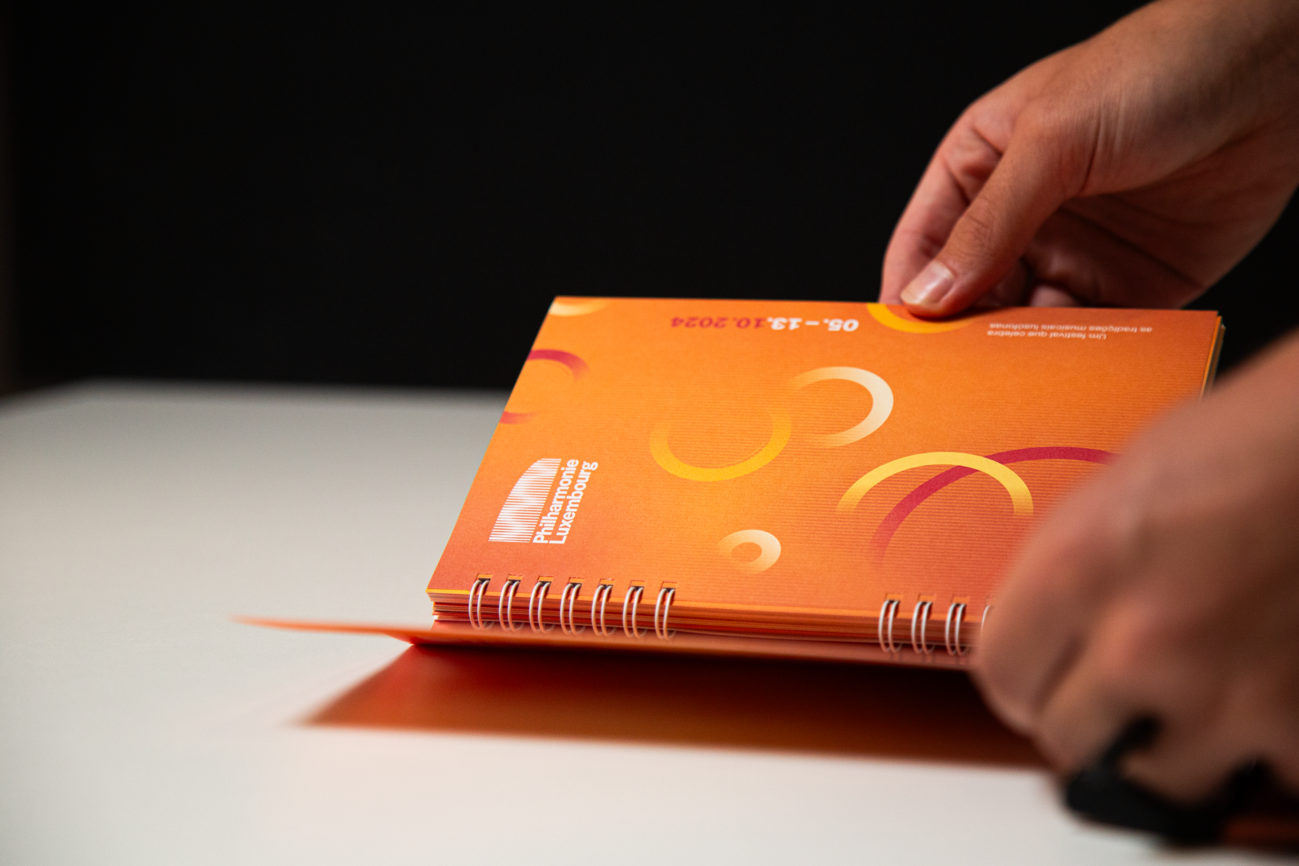 Mise en page du dépliant imprimé orange présentant le programme du festival musical Atlântico 2024.