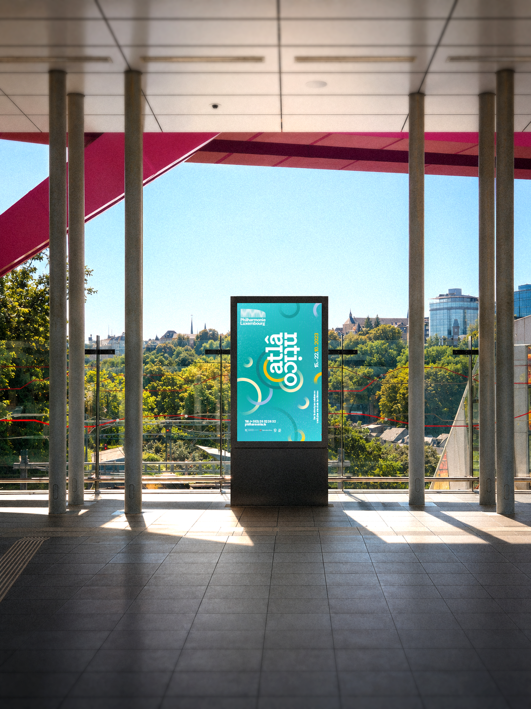 Mockup d'écran publicitaire diffusant l'affiche bleue du festival Atlântico à la gare de Pfaffenthal.