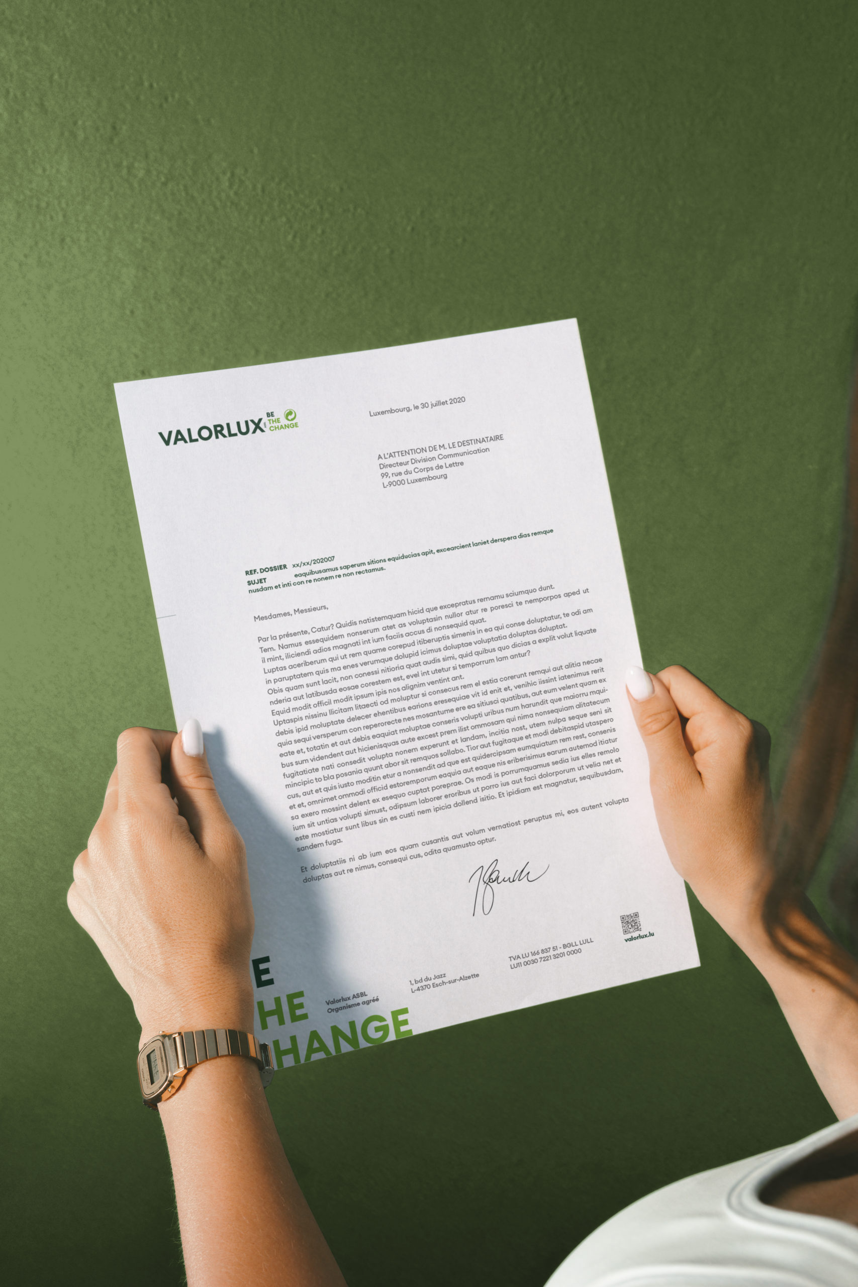 Mockup de carte de visite Valorlux illustrant le slogan Be The Change sur un décor en bois naturel.