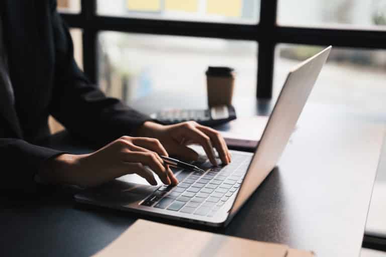 Personne tapant sur un ordinateur portable dans un environnement de travail
