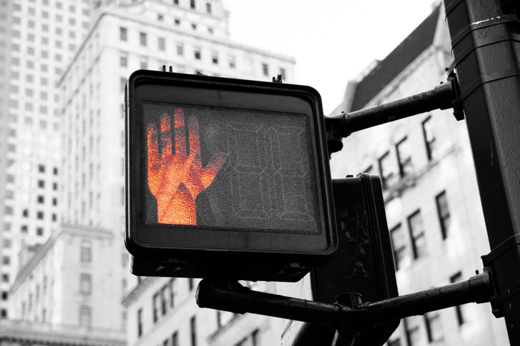 Signal piéton lumineux affichant une main rouge, en référence aux contrôle des cookies avec le RGPD