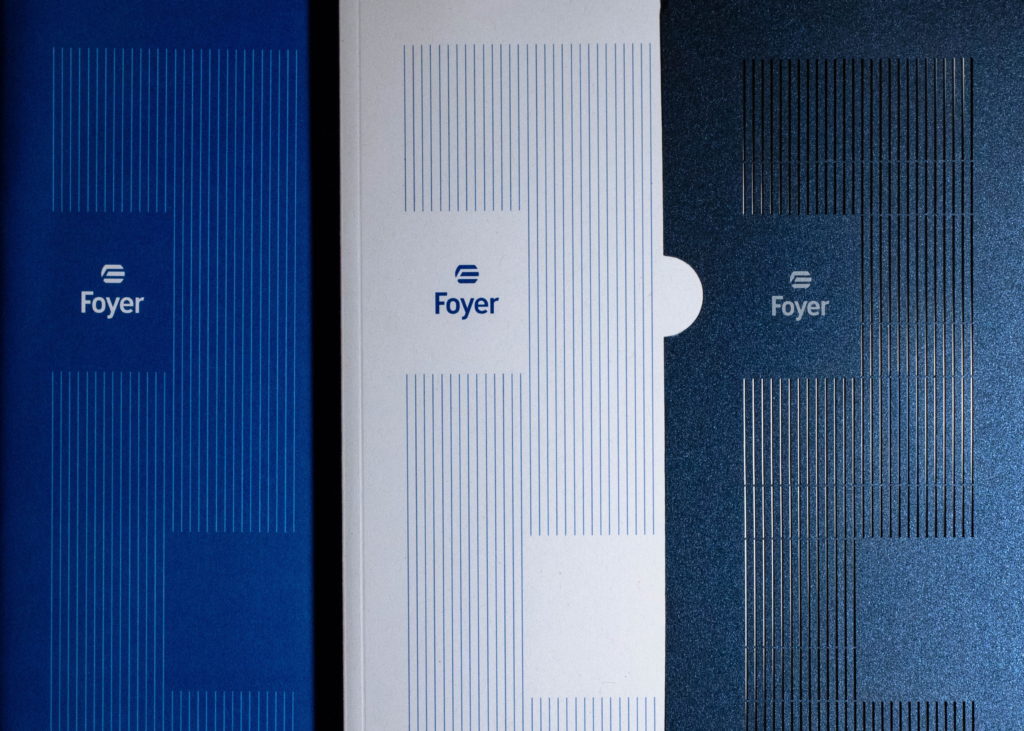 Trois couvertures de livrets Foyer de couleurs bleue, blanche et bleu foncé texturé avec un motif de fines lignes verticales.