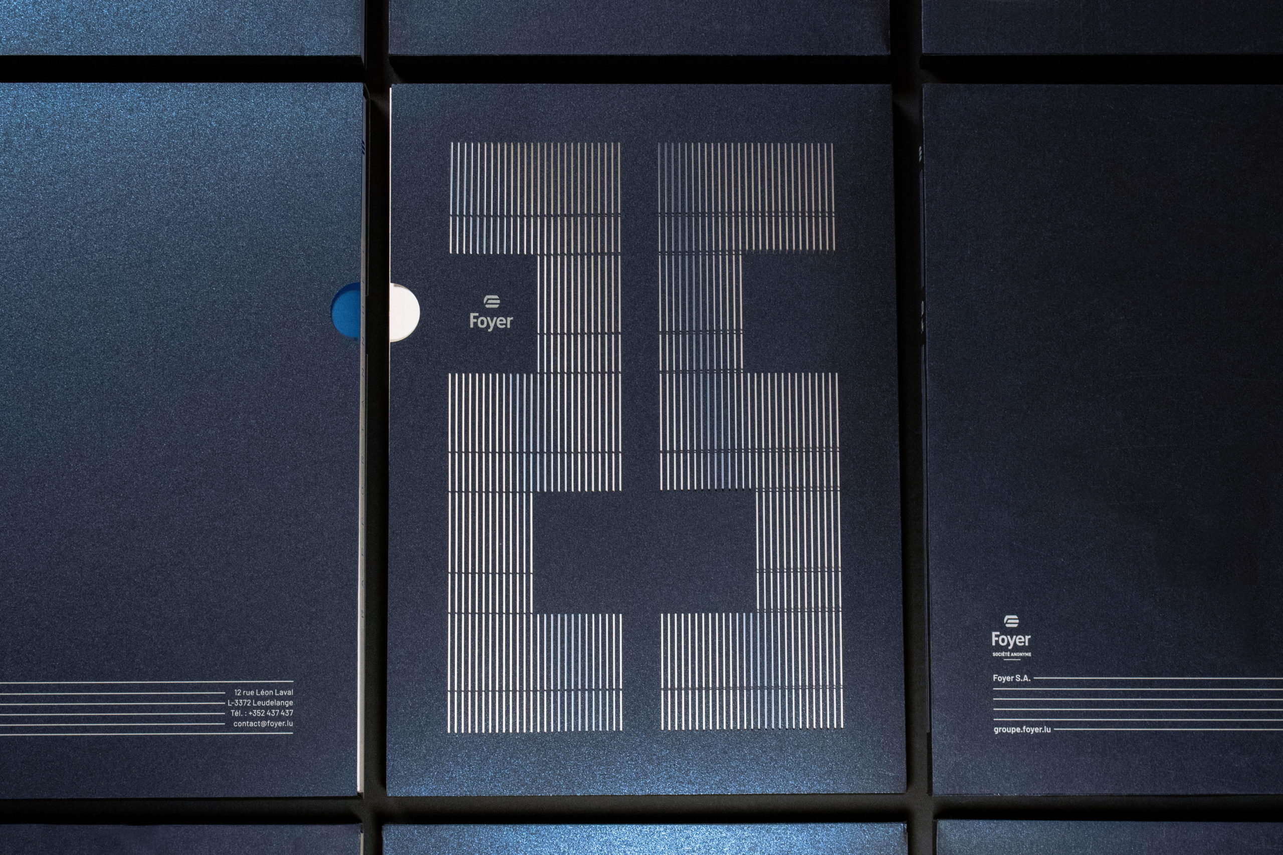 Couverture de rapport bleu foncé pailleté avec le chiffre 25 stylisé en lignes argentées et les coordonnées textuelles en bas à gauche.