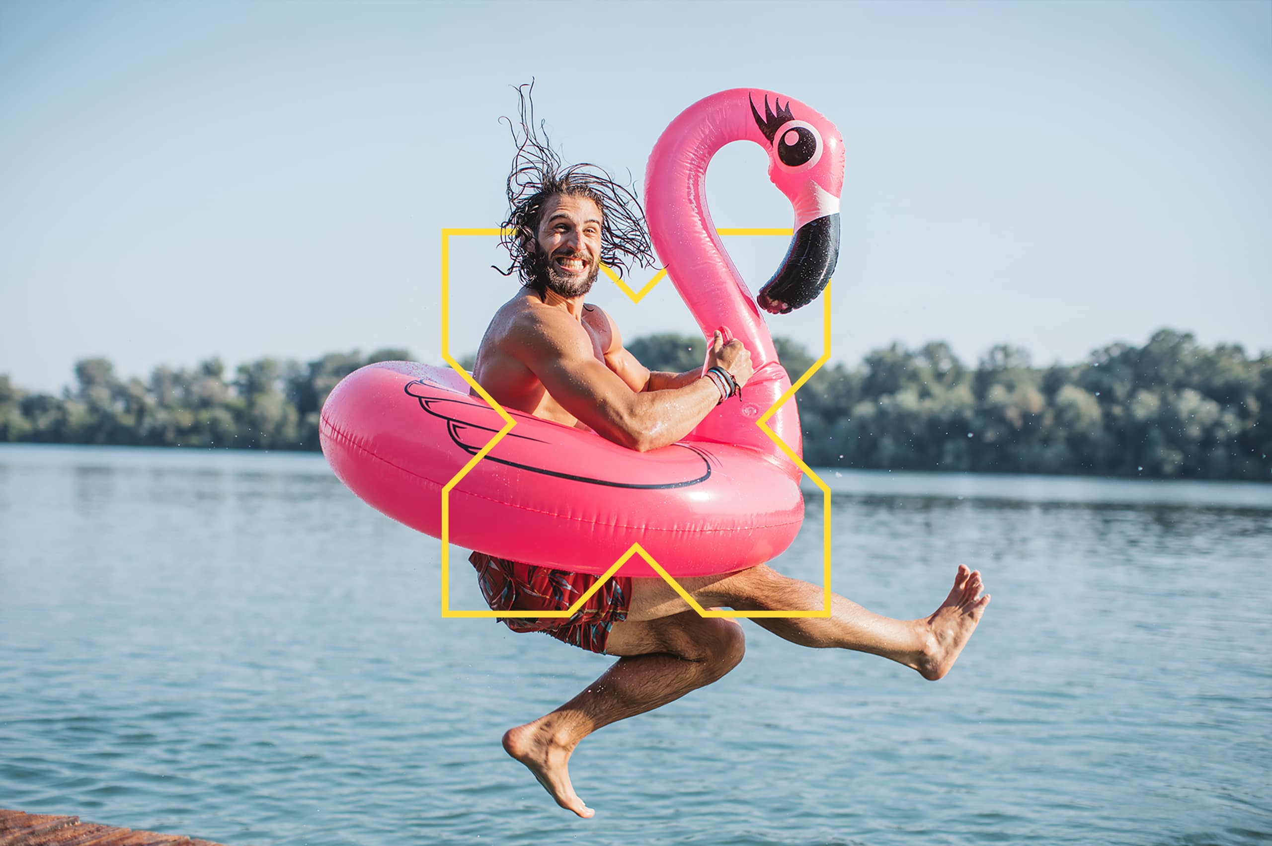 Personne s’amusant sur une bouée rose en forme de flamant, sur un lac en été.