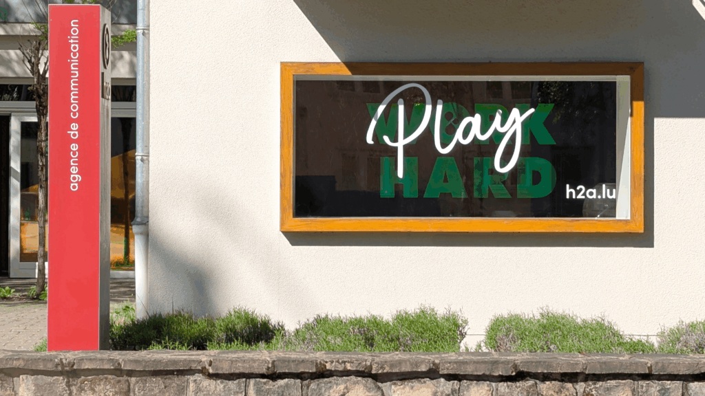 façade de l'agence h2a avec écrit sur la vitre "work hard play hard"