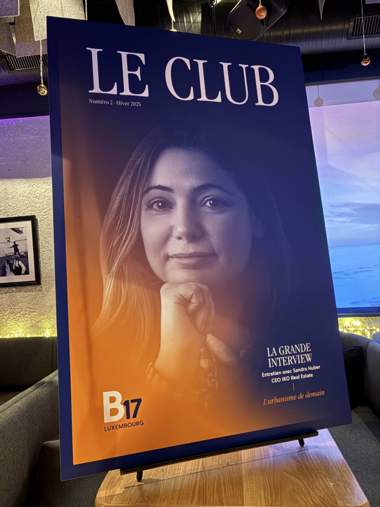 Affiche du magazine « Le Club », numéro 2 hiver 2025, montrant le portrait en noir et blanc d’une femme posant le menton sur la main. Texte : « La grande interview – entretien avec Sandra Huber, CEO IKO Real Estate ». Logo B17 Luxembourg en bas de l’affiche.