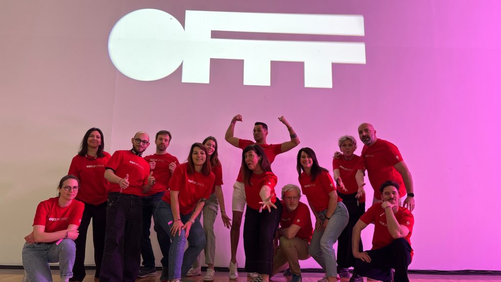 l'équipe de l'agence h2a en t-shirts rouges pose devant le logo du festival OFFF sur fond rose.