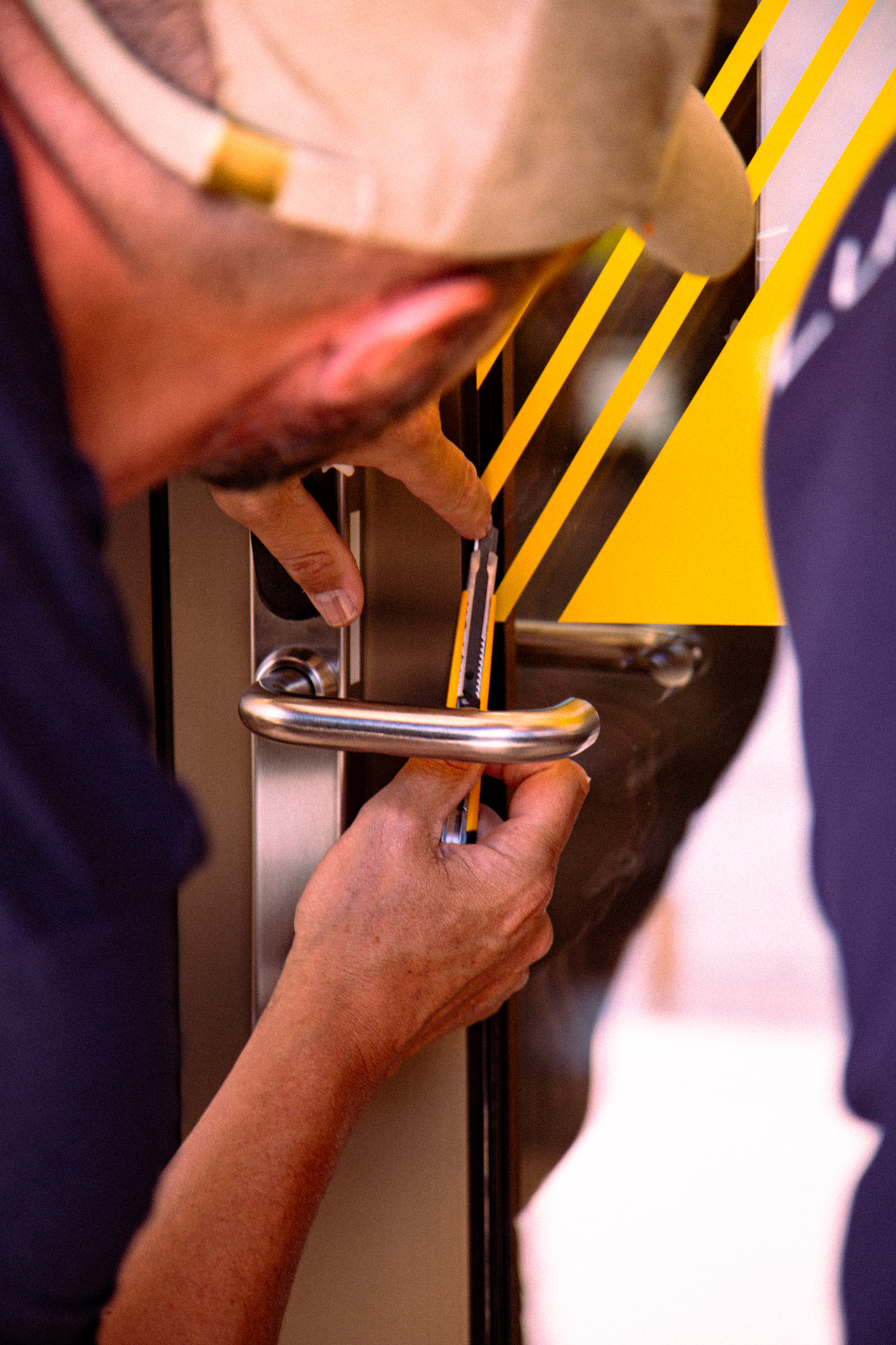 Poseur LuxVisual posant la signalétique adhésive jaune sur une porte vitrée de la mairie