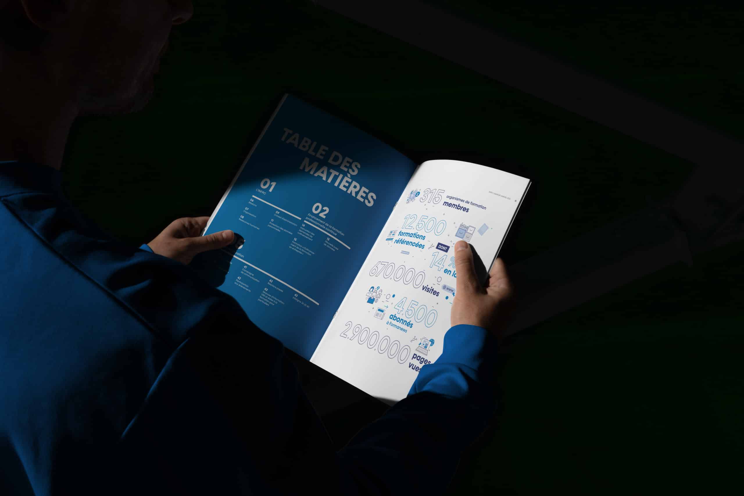 Personne consultant une brochure ouverte de l'INFPC, affichant la table des matières et une page d'infographies.
