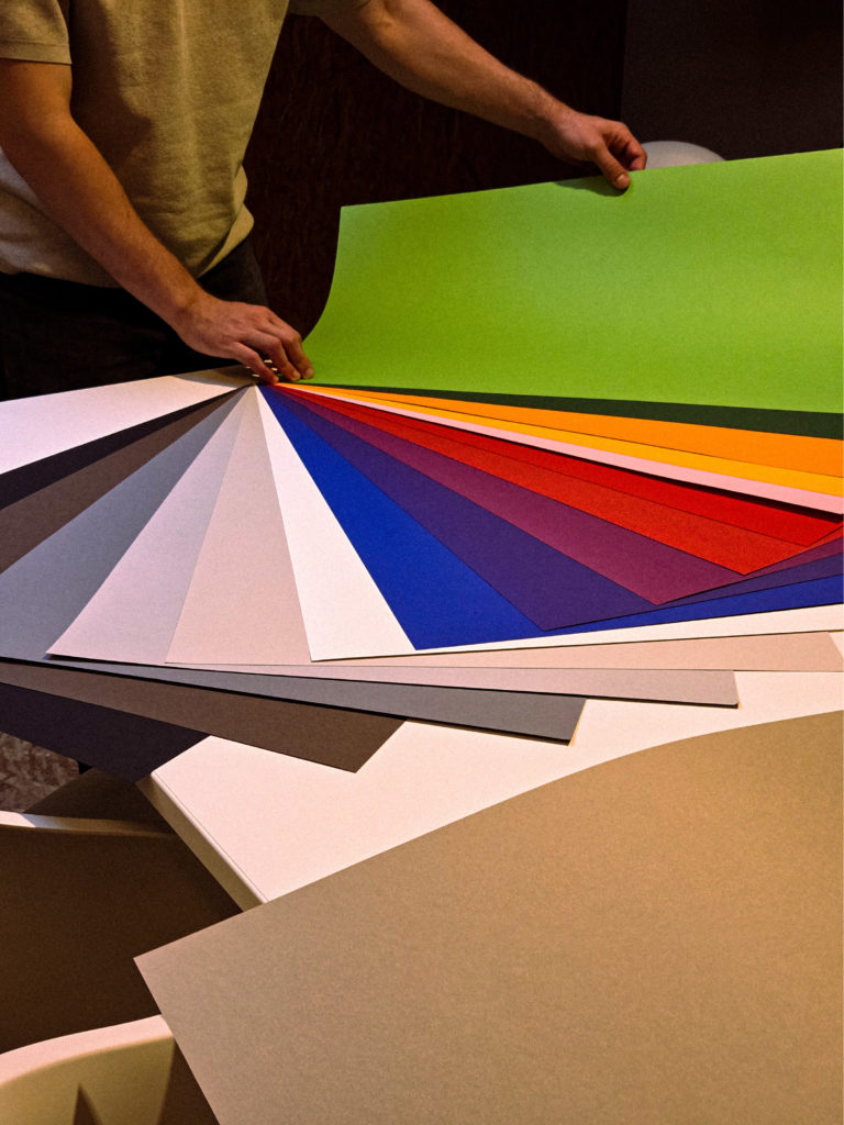 Sélection de couleurs sur un nuancier géant lors des projets créatifs de l'agence en août.