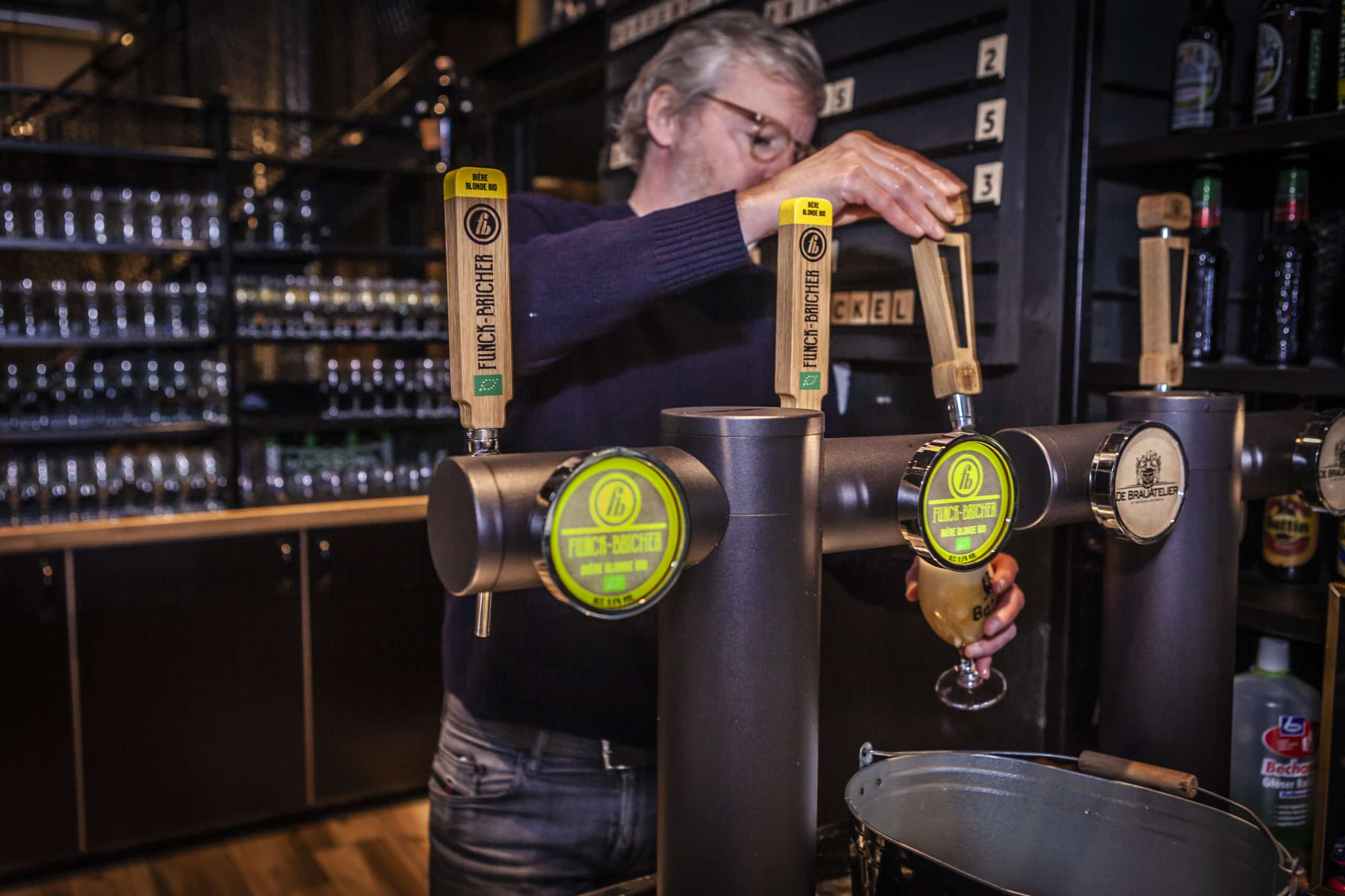 Homme versant une bière à la tireuse depuis un bec Funck-Bricher.