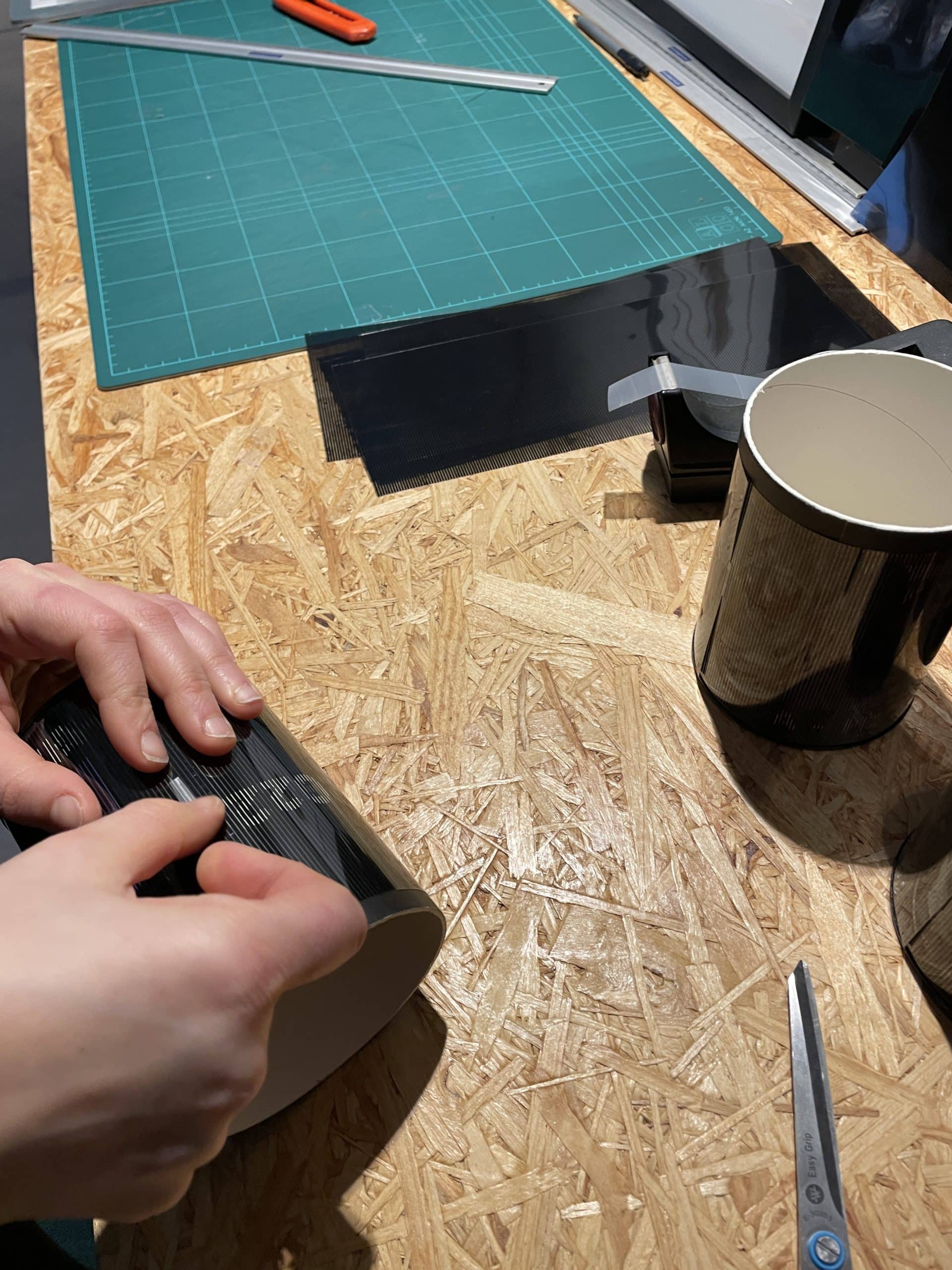 Assemblage manuel du packaging cylindrique noir sur mesure pour les cadeaux d'entreprise.