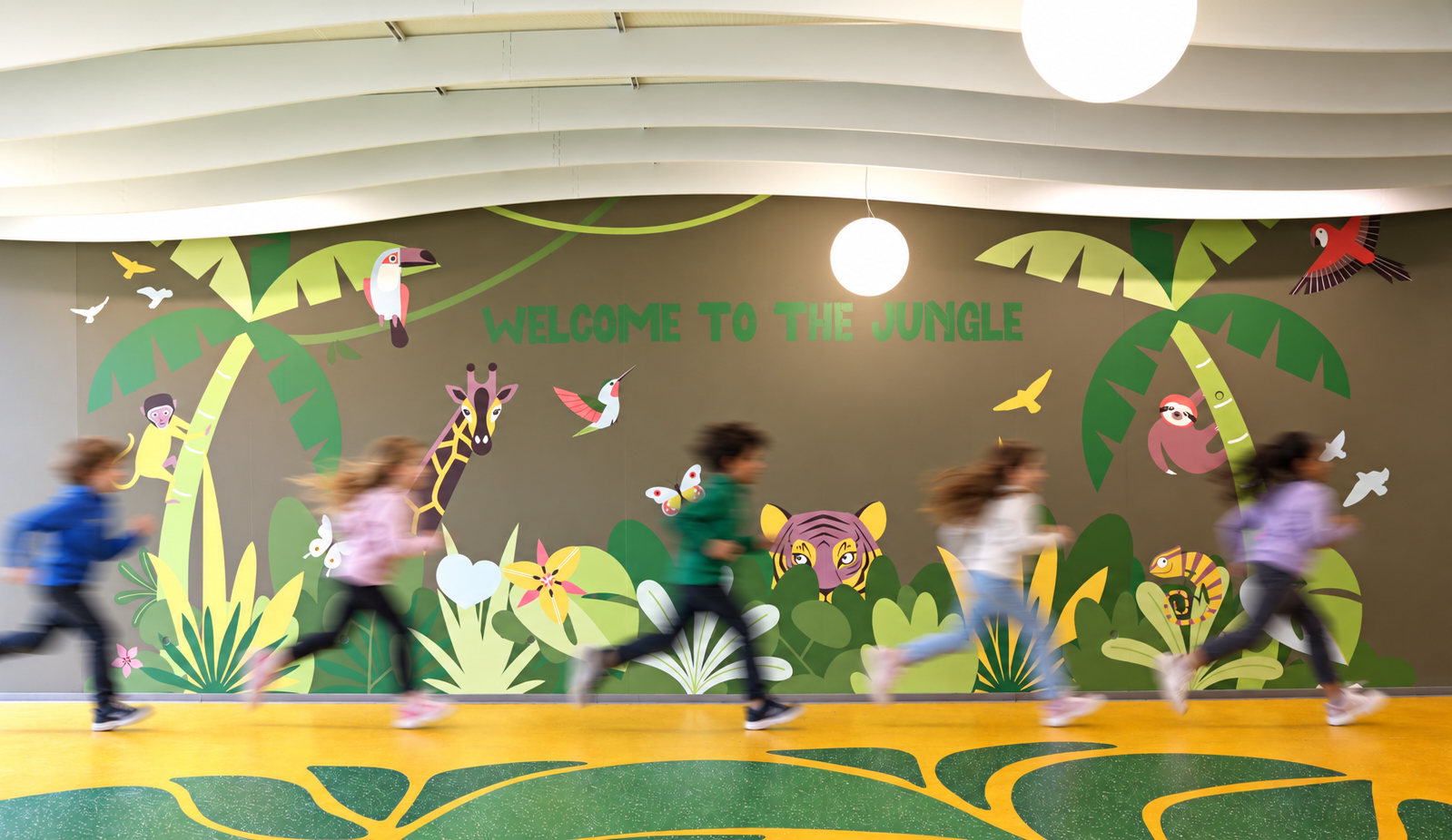 Cinq élèves courant devant une fresque murale 'WELCOME TO THE JUNGLE' ornée d'animaux tropicaux, sur un sol jaune à motifs de feuillages